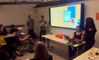 students present work on large tv screen in full classroom