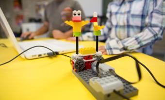 student playing on computer to move around a robot