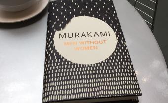 book sitting on cafe table next to cup of coffee