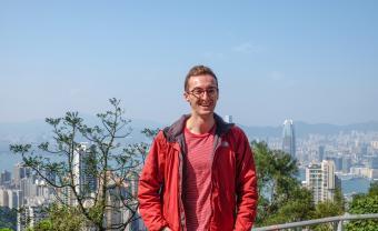 student outside smiling overlooking California hills