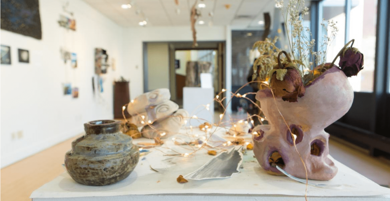 exhibition with pottery and other ceramic items on display in gallery