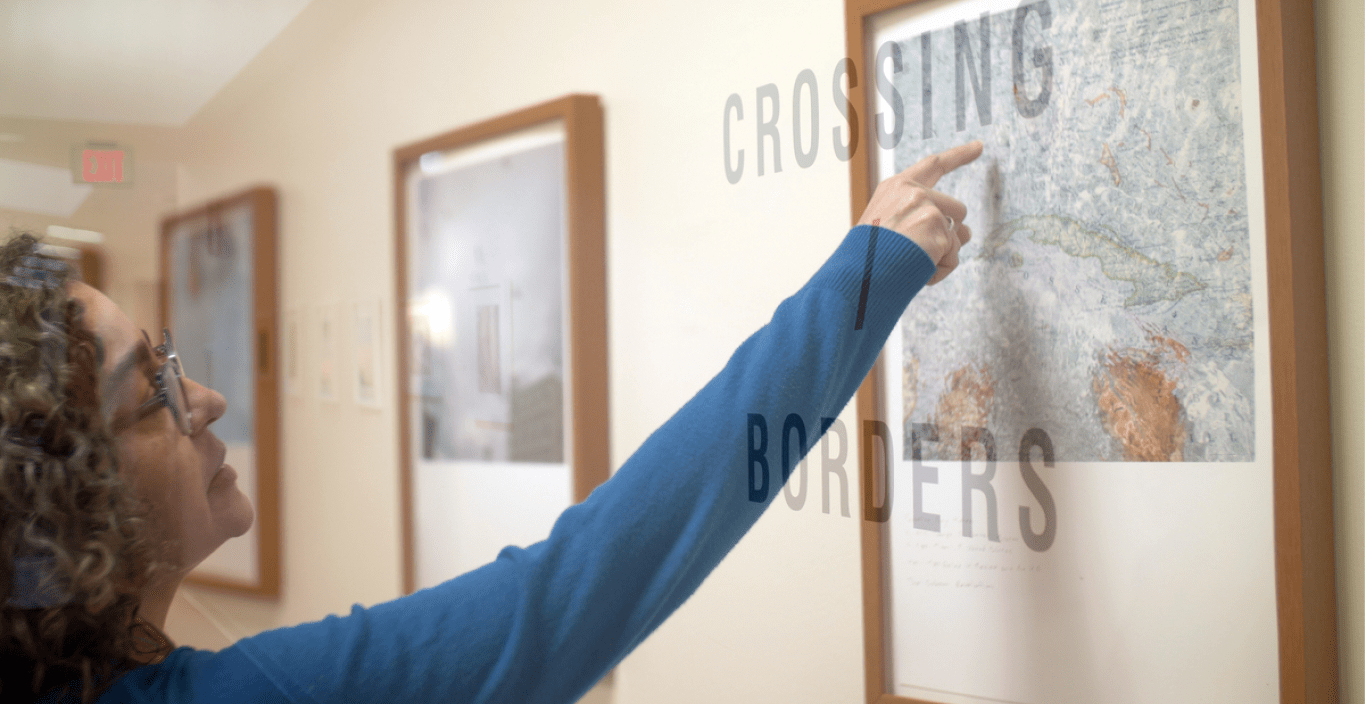 woman points to photograph on wall