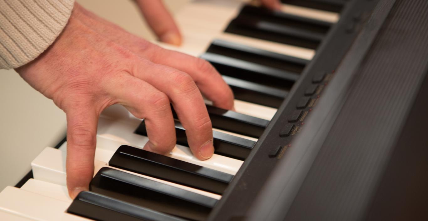 elderly hands playing a piano