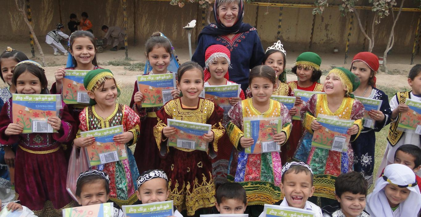 Professor Louise Pascale and a group of Afghan children with their songbooks
