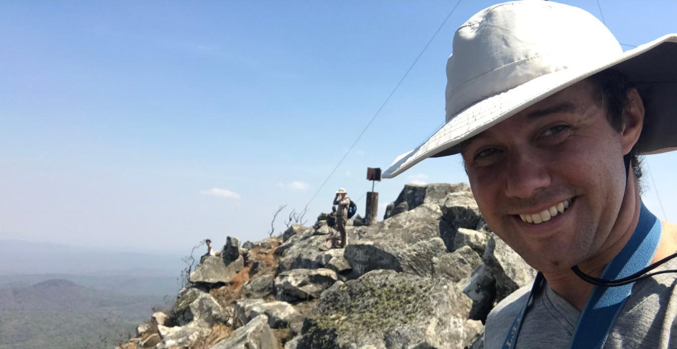 Alexander Dunn wearing a hat standing on rocky terrain