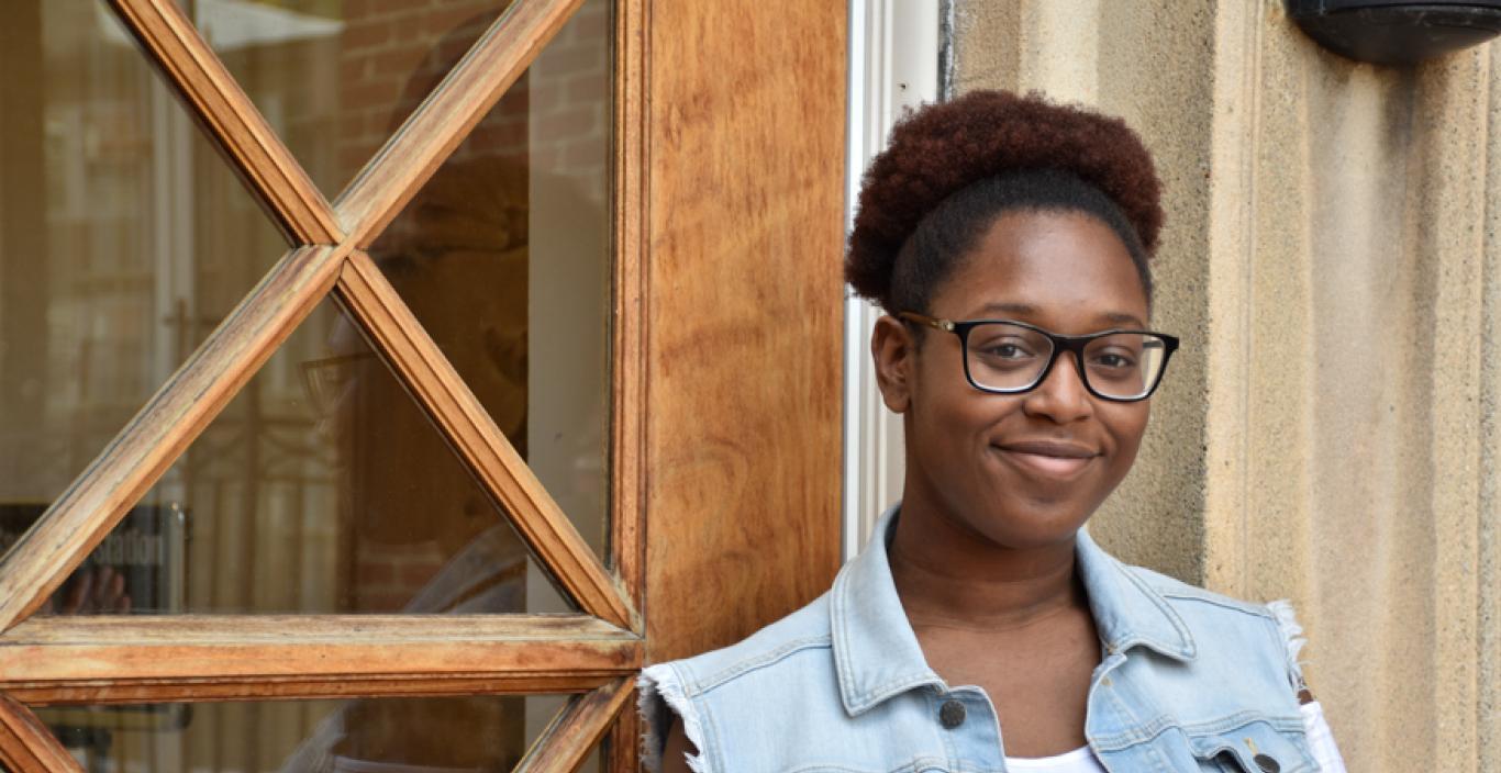 Chaurice Miller stands outside near a window