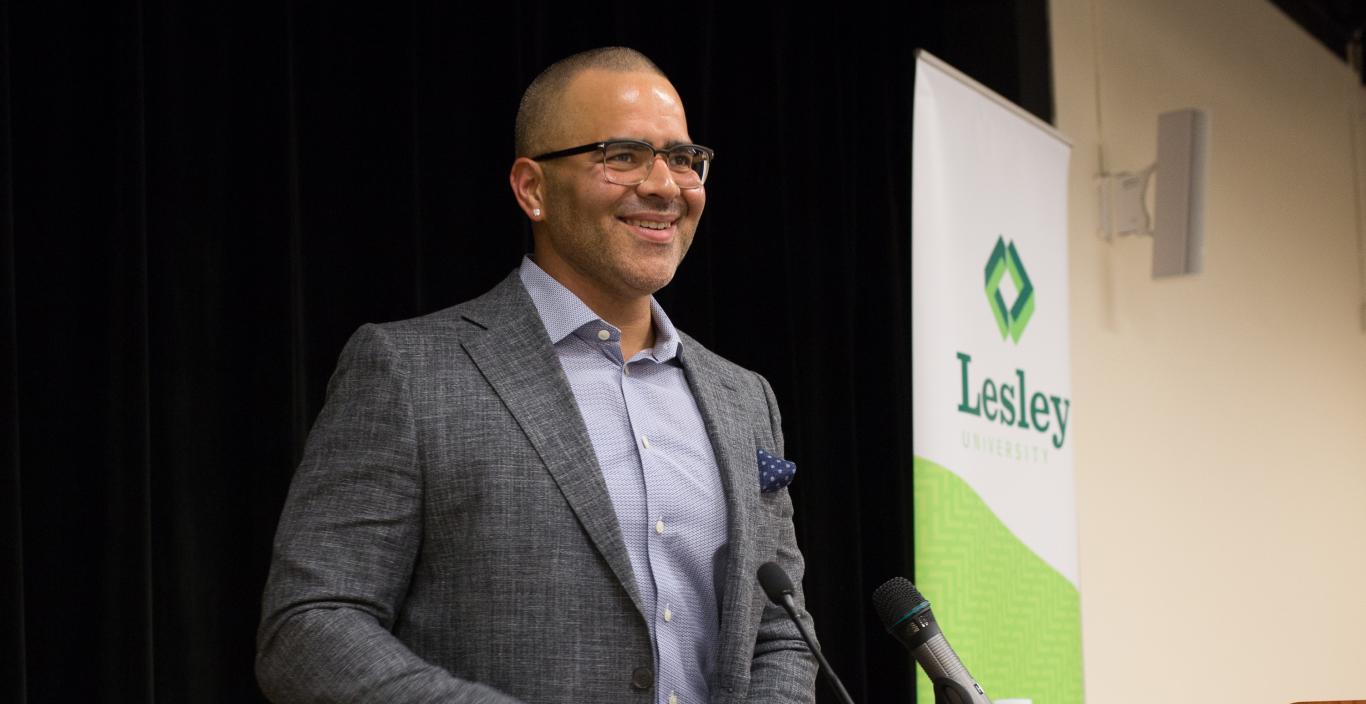 Christopher Jackson stands at the podium smiling.