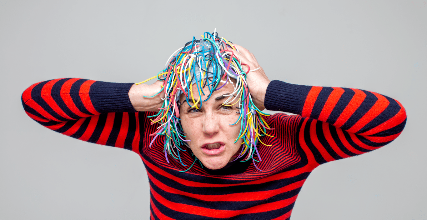 Eileen Powers in a striped shirt and one of the "heads" she and her collaborators designed.