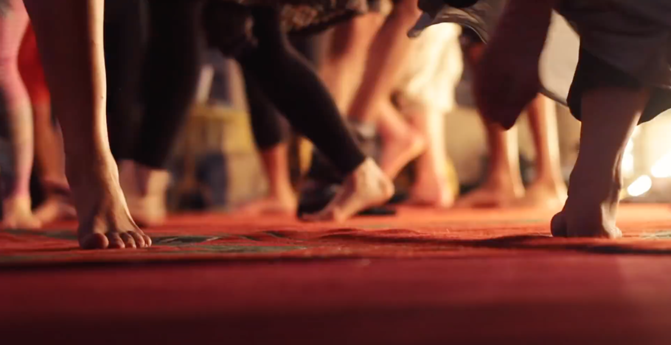 A ground level shot of human feet dancing and moving in the foreground and background. 