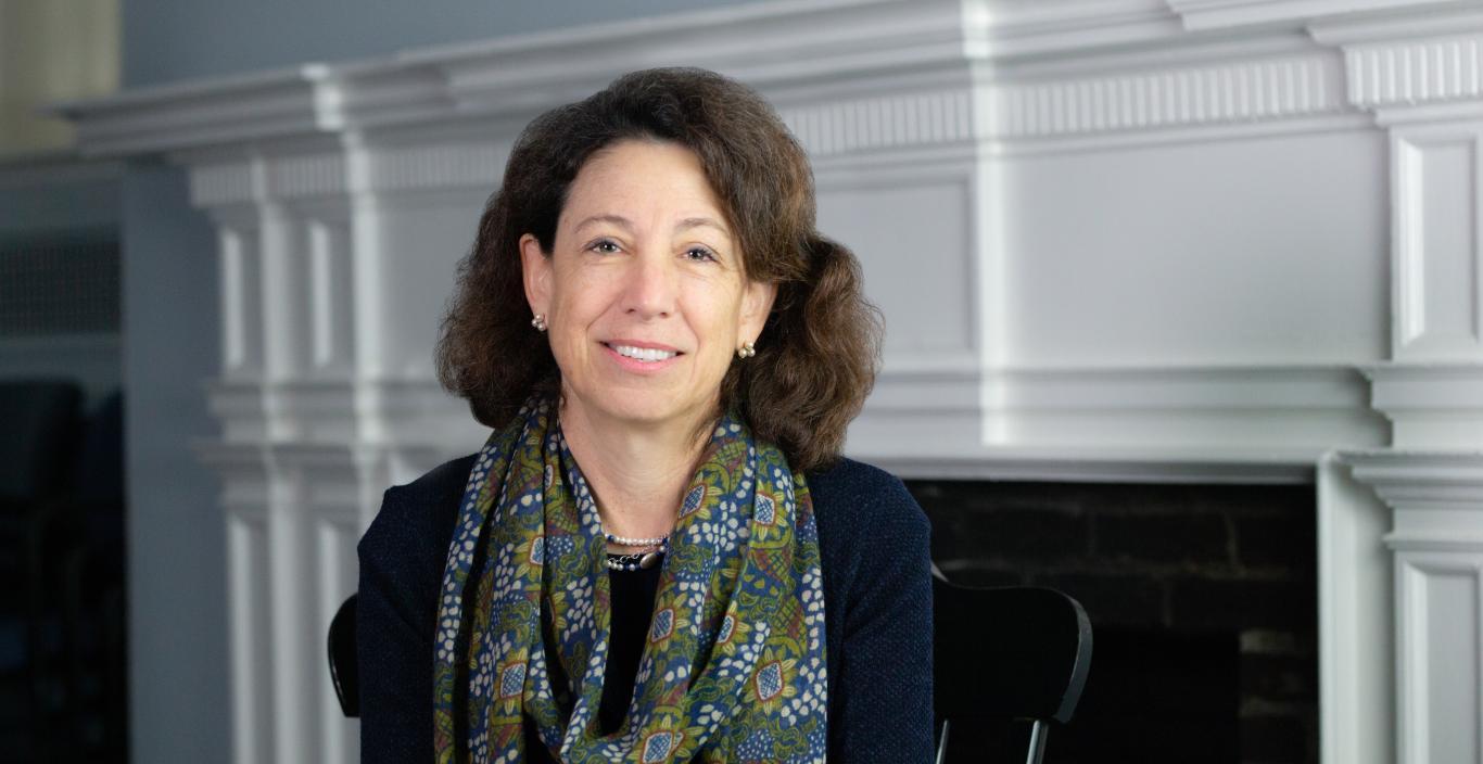 President Janet Steinmayer is wearing a scarf and dark sweater and smiling.