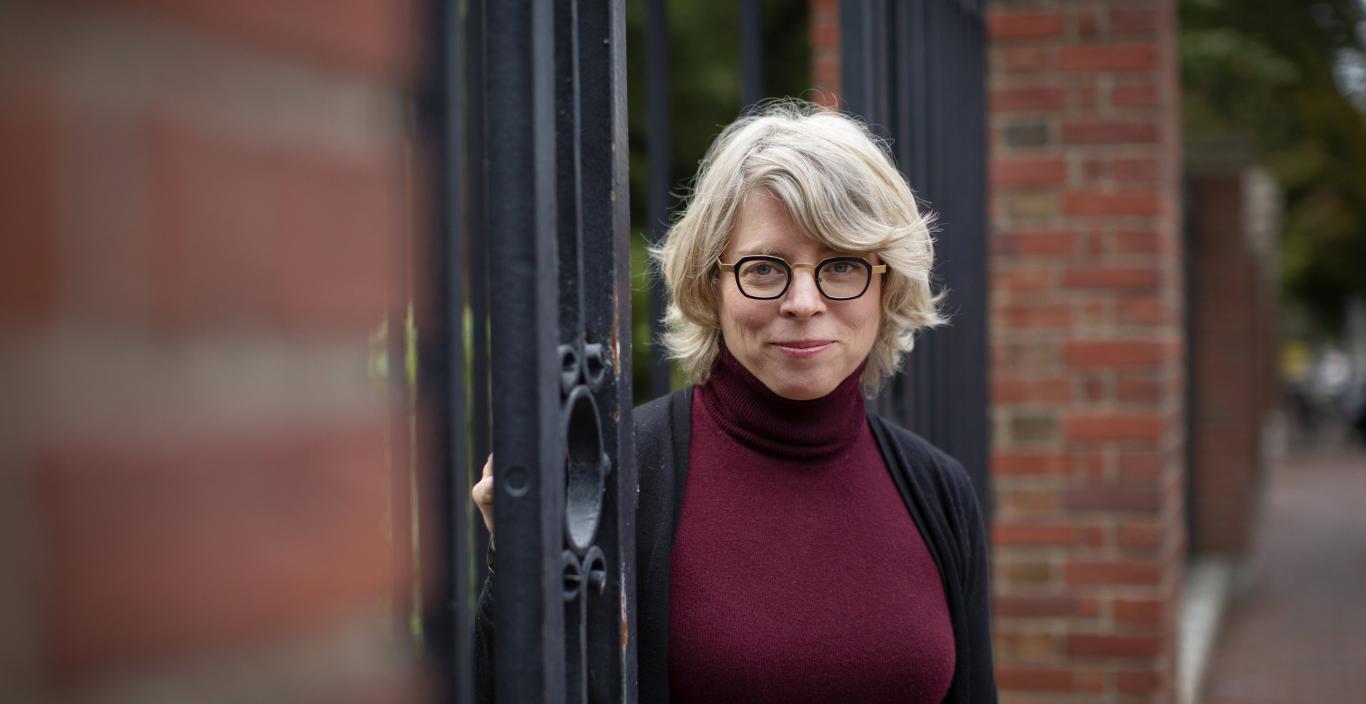 Photo of Jill Lepore standing in Harvard University gates