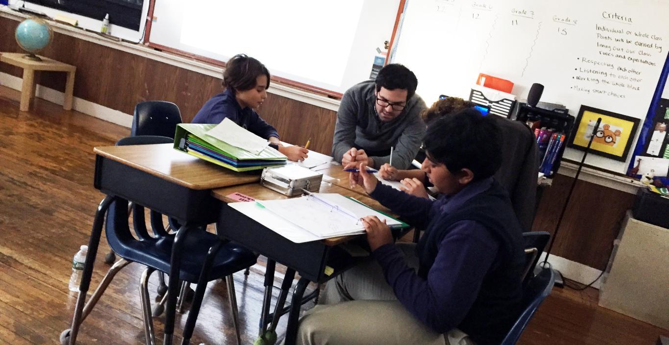 Alumnus Kevin DeCosta teaches students in his social studies classroom
