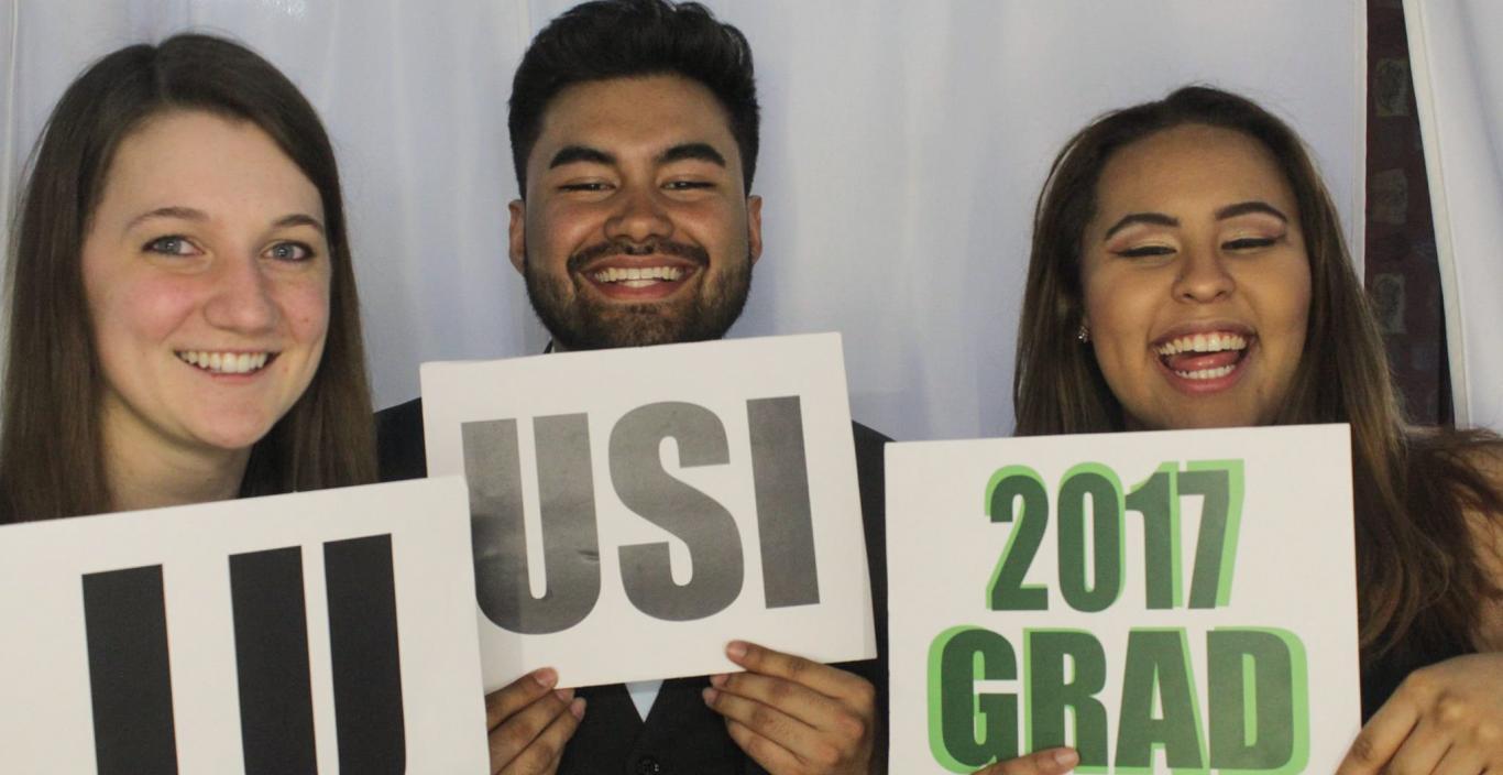 Students hold up signs reading LU, USI and 2017 Grad