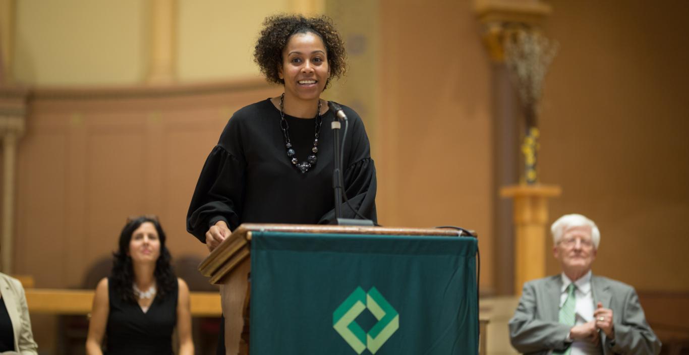 Maritsa Barros speaks at a podium in the church.