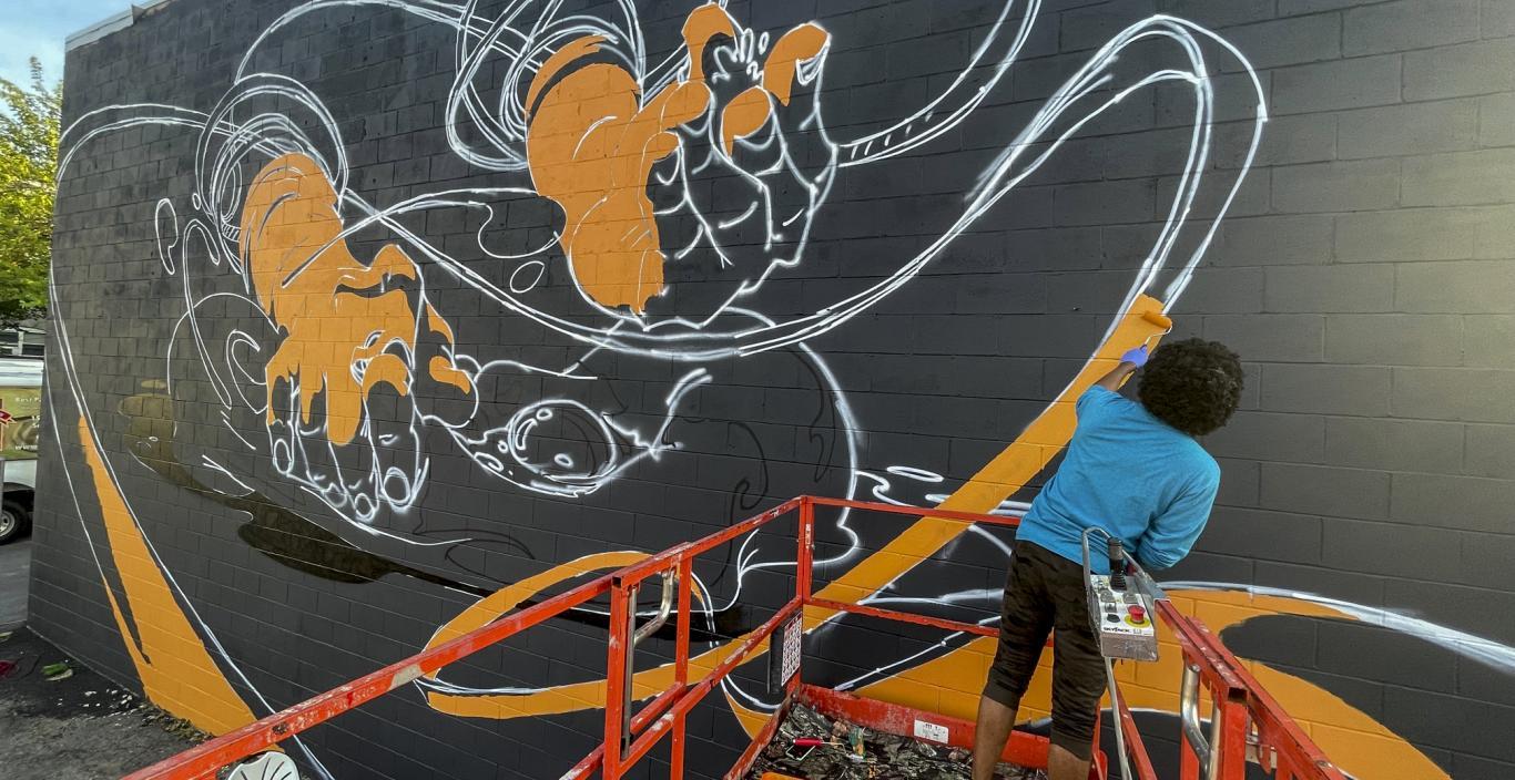 Michael Talbot works on his East Somerville mural "Artisanal."