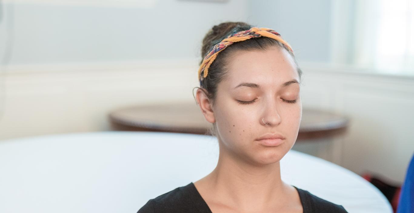 Young woman meditating with eyes closed