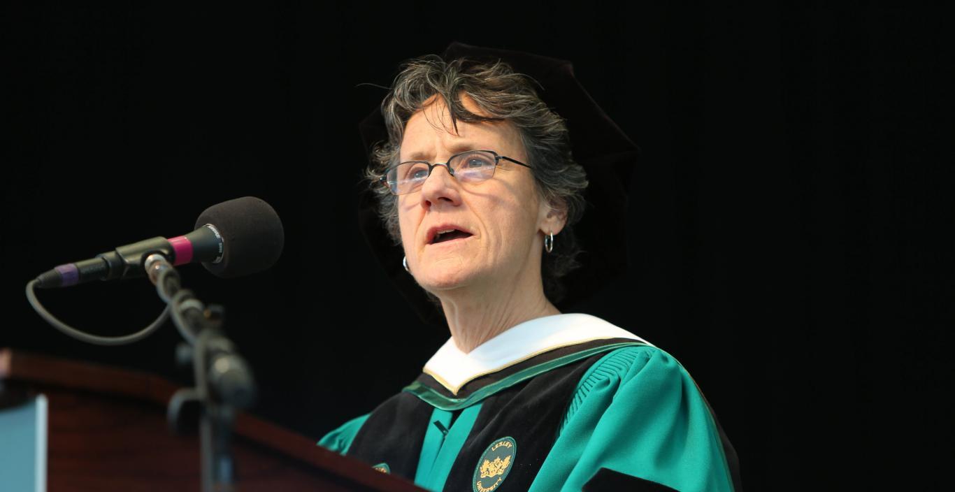 Molly Baldwin in cap and gown speaking at podium