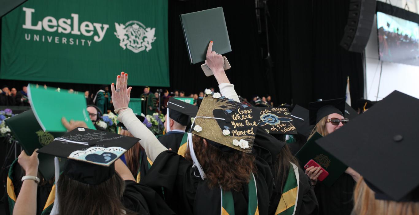 A view of the graduates in the audience with the Lesley banner in the background.
