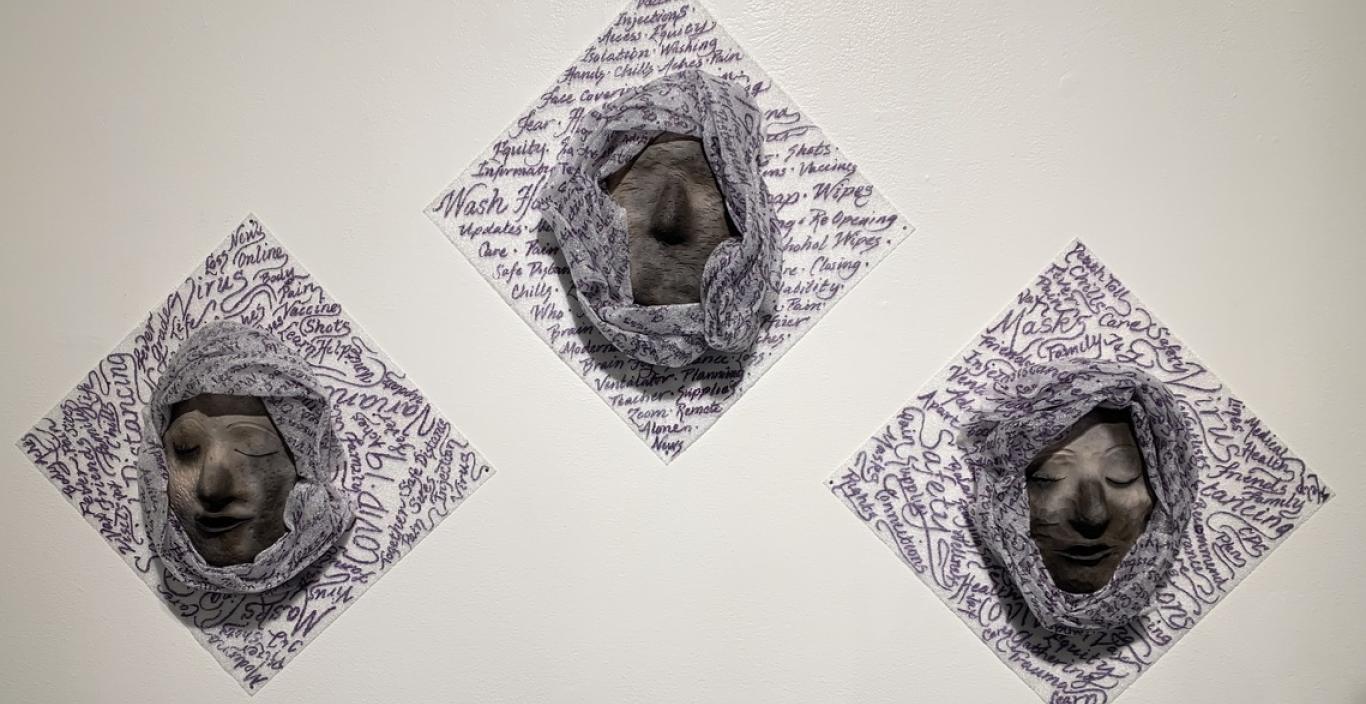 Three sculpted masks on a wall