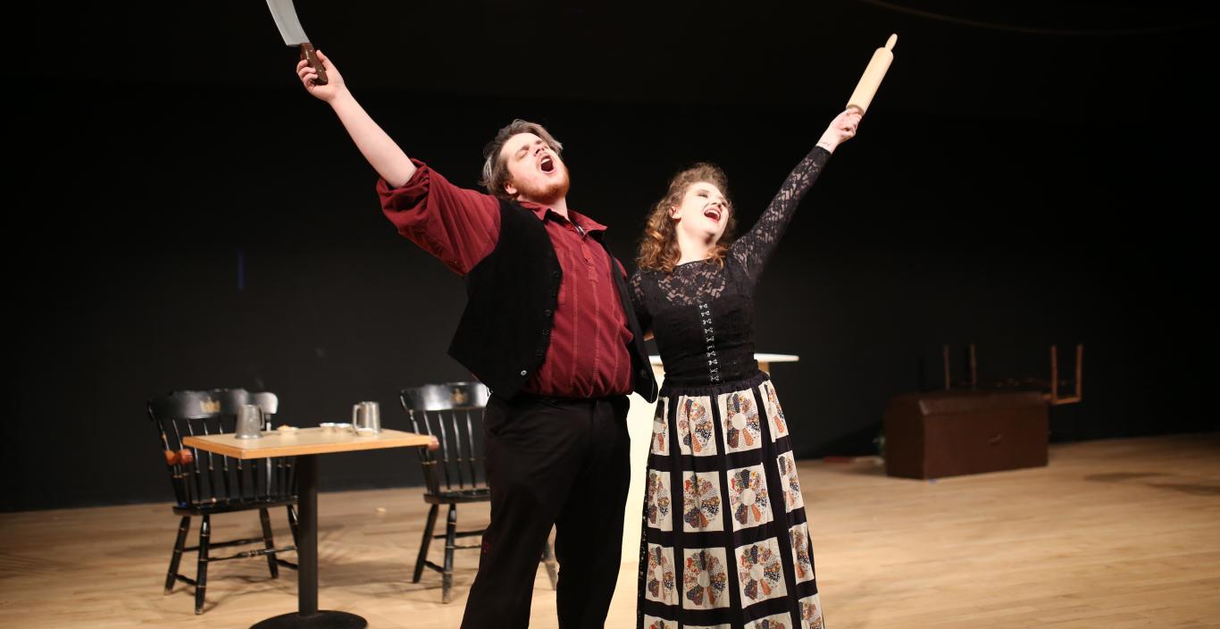 Two students are singing on the stage.