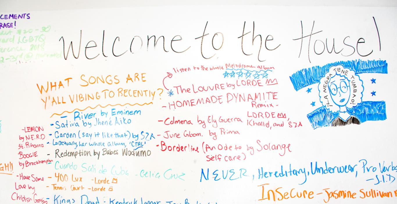 White board covered in song titles, says "Welcome to the House" at the top.