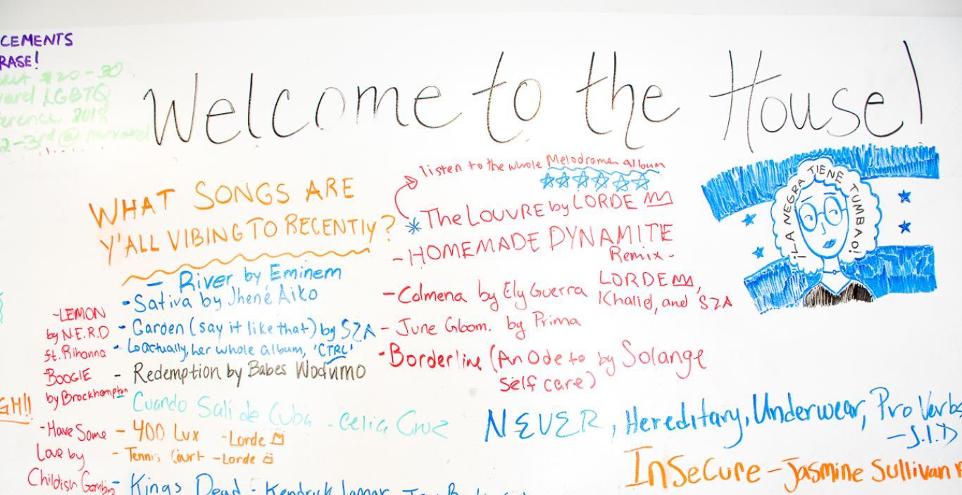 White board covered in song titles, says "Welcome to the House" at the top.
