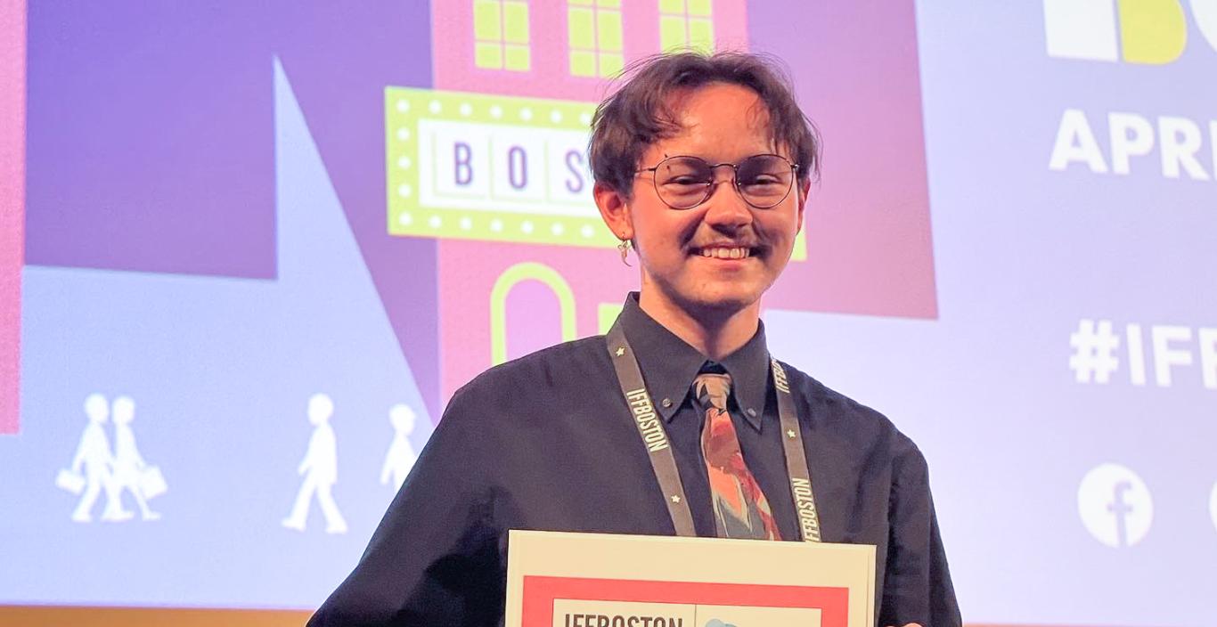 Thomas Tague-Bleau holding a certificate at film festival.