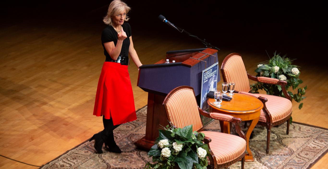Woman giving a speech on a stage behind a podium