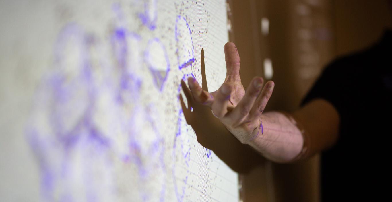 instructor giving a lecture pointing at screen using 3d animation software