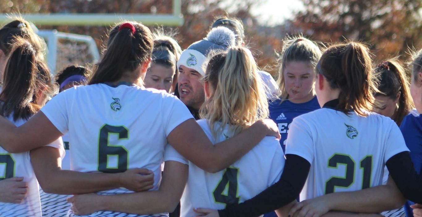 Coach Paul Vasconcelos amid player huddle