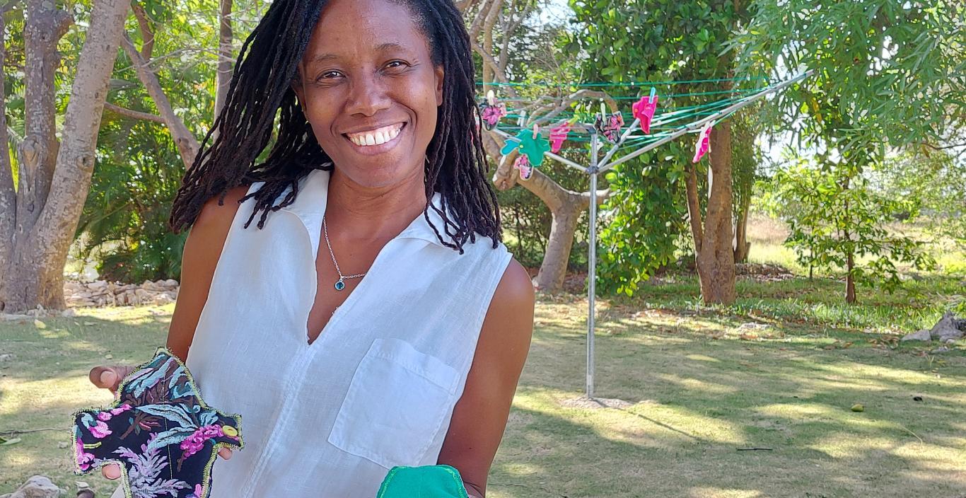 Cherith Pedersen standing outside holding two handmade menstrual pads