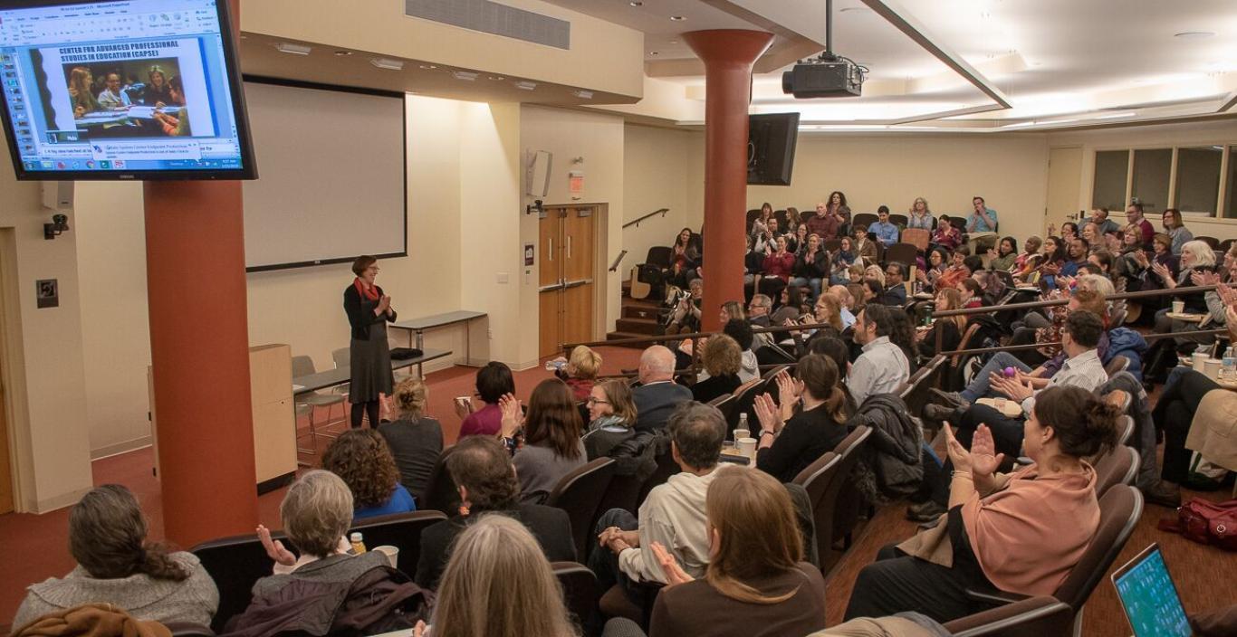 Wide audience shot, people clapping