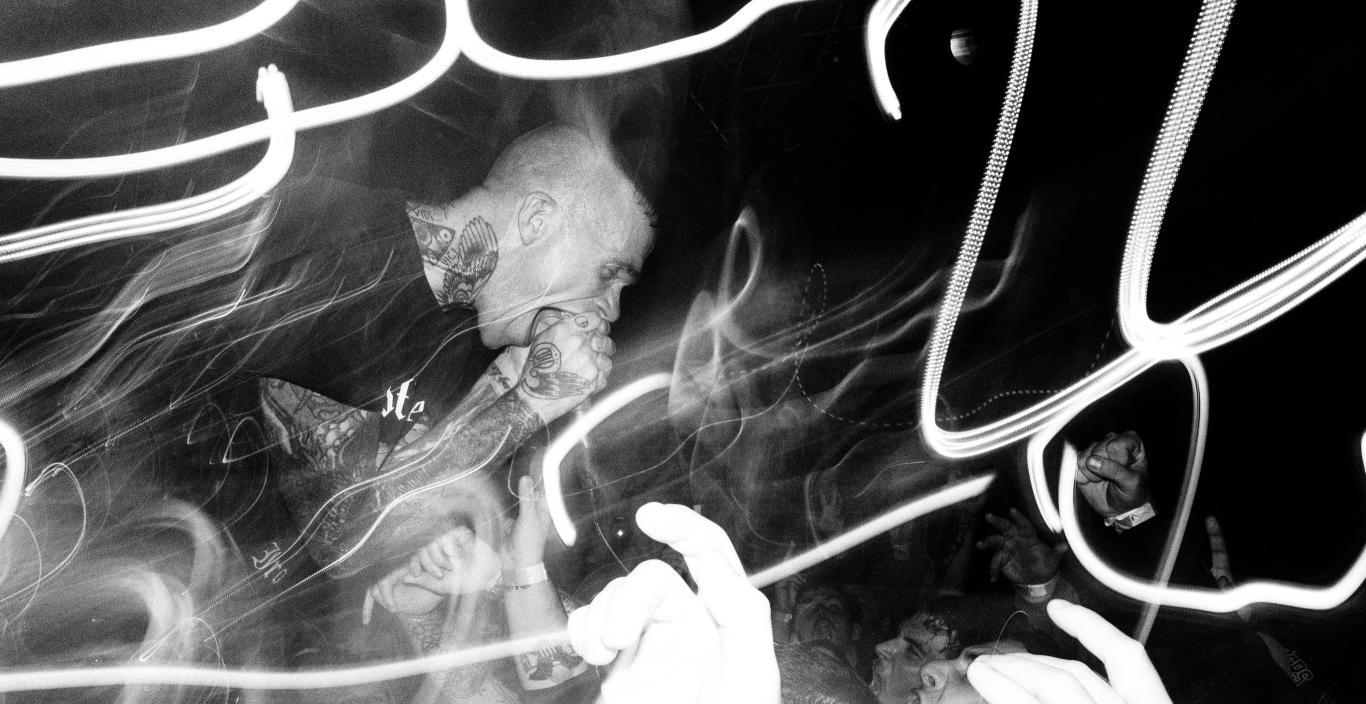 black and white photo of lead singer performing in front row of concert