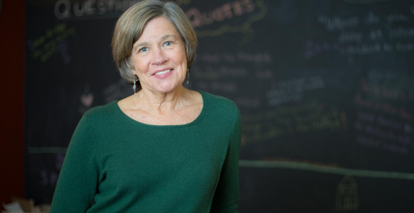 Nancy Carlsson-Paige standing in front of chalkboard smiling