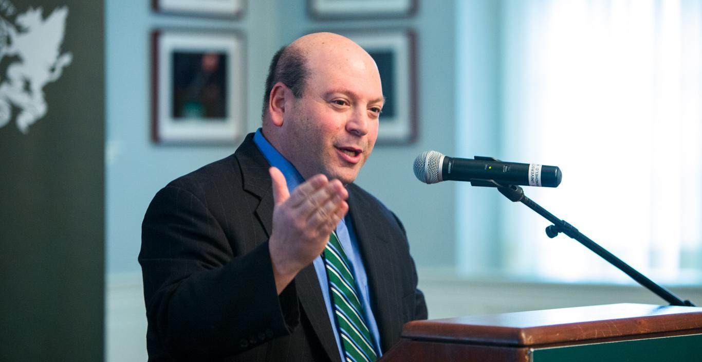 university president Jeff Weiss speaking at a podium