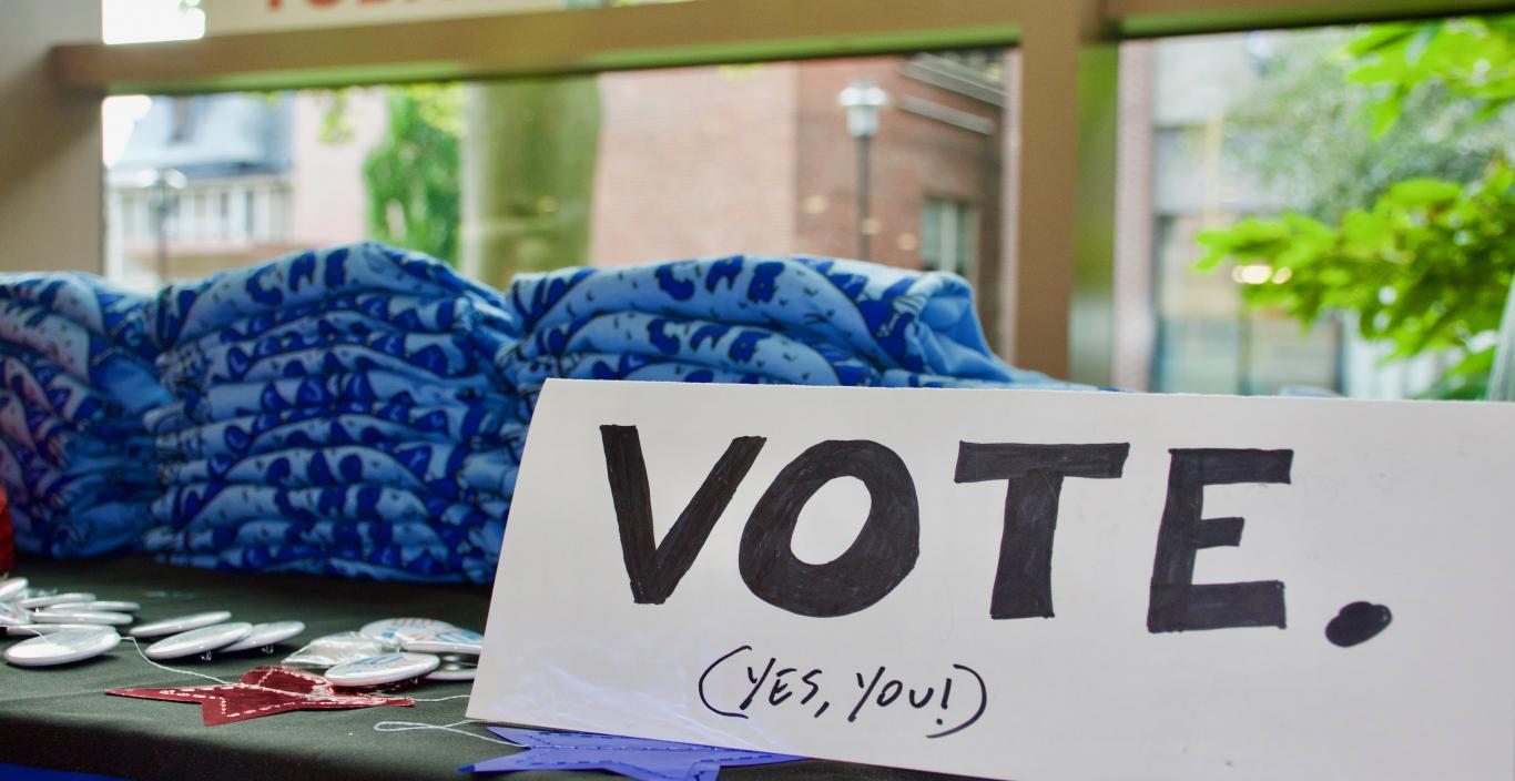 Voter registration table in the student center with signs and tshirts