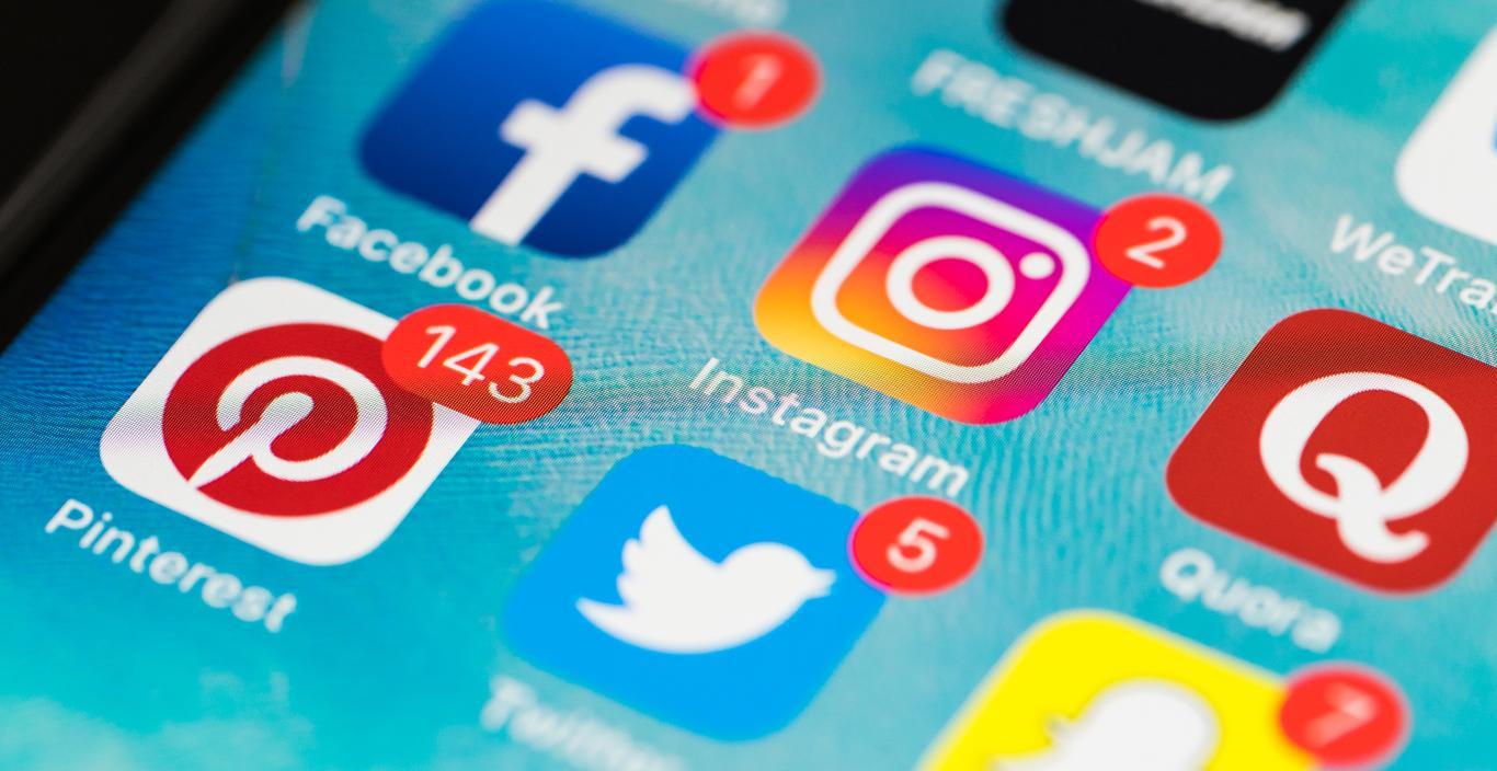 Close-up of a cell phone screen with social media icons displayed.