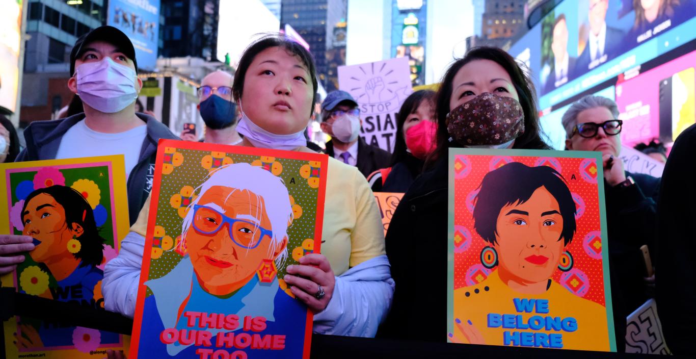 Stop Asian Hate Rally in Times Square - women holding images of asian people with words stop asian hate