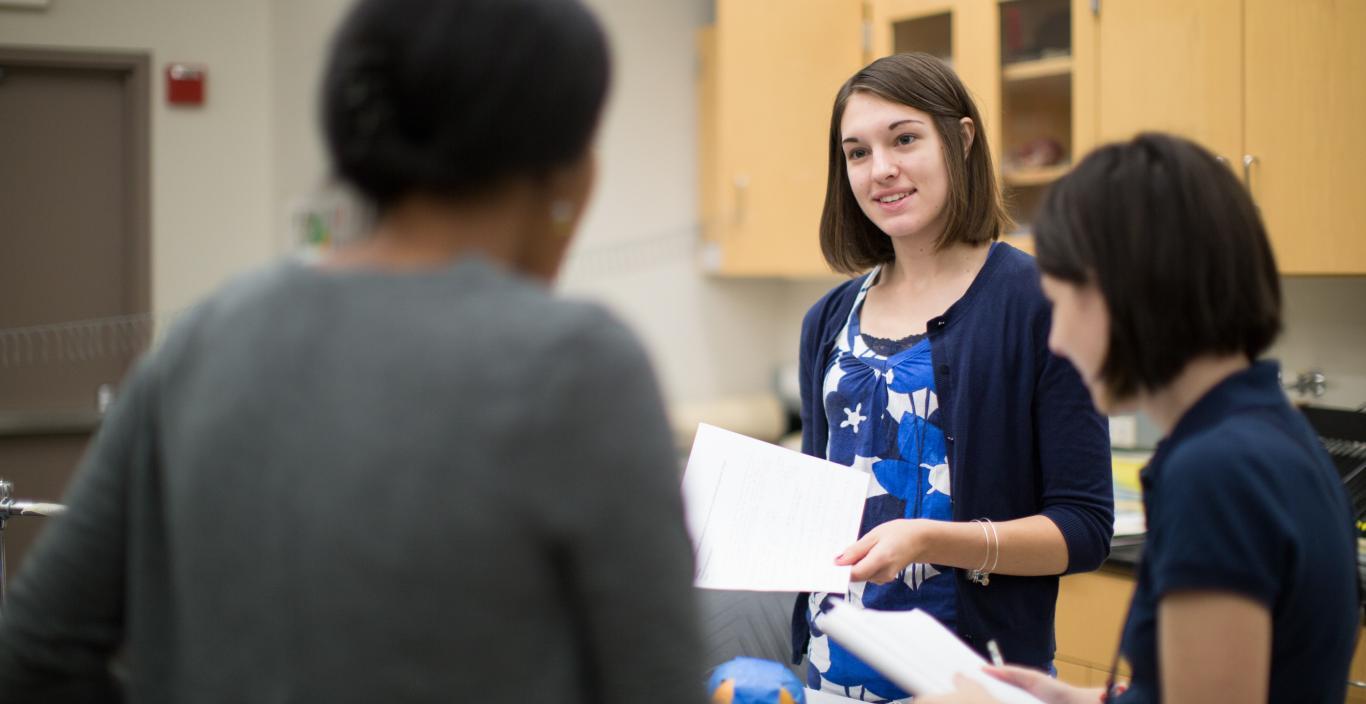 Hannah Willis speaking to her classmates in a lab