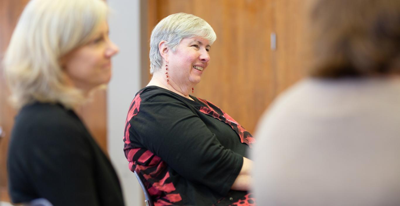 Sue Motulsky smiling between two people.