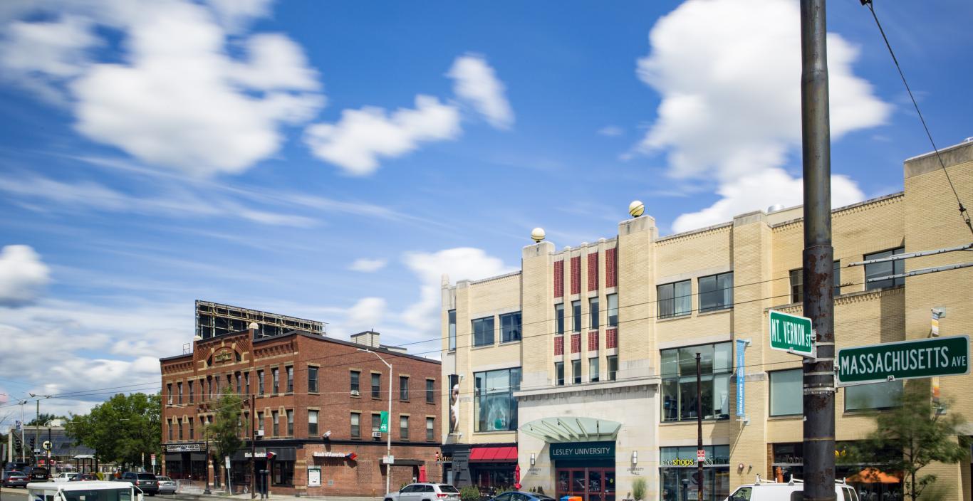 Buildings on a busy city street with blue sky and clouds