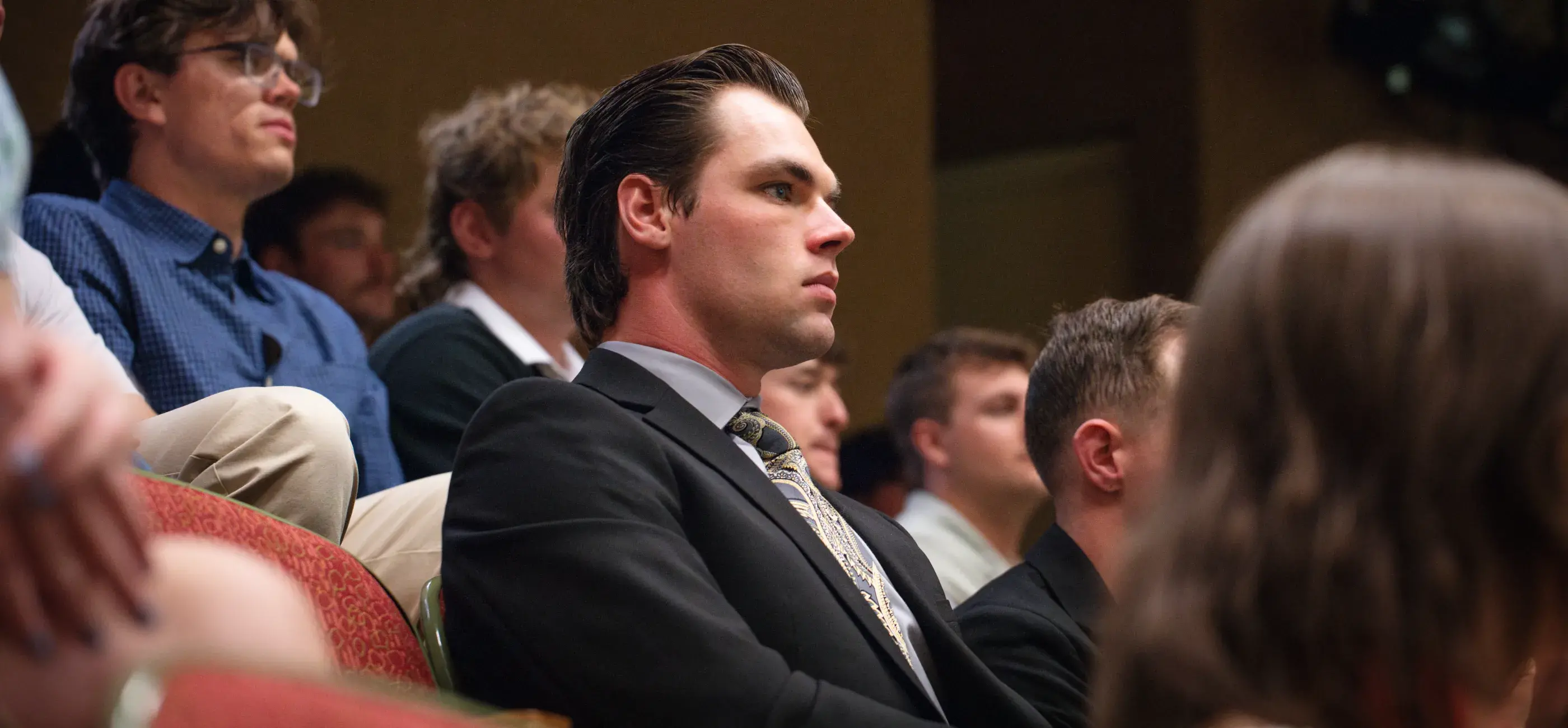 People sitting in a crowd watching an awards ceremony
