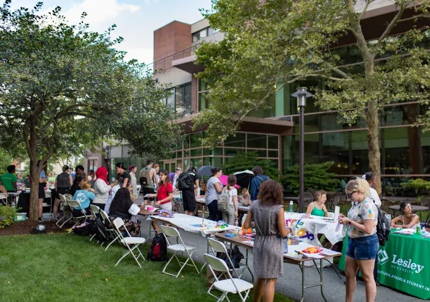 A row of outdoor tables with students on either side