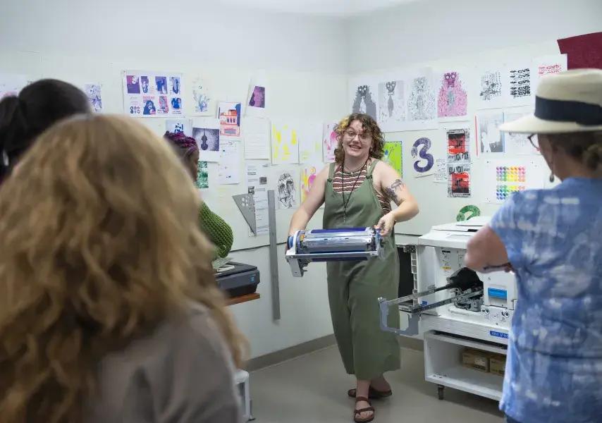 woman in green jumpsuit replacing the color ink in printer
