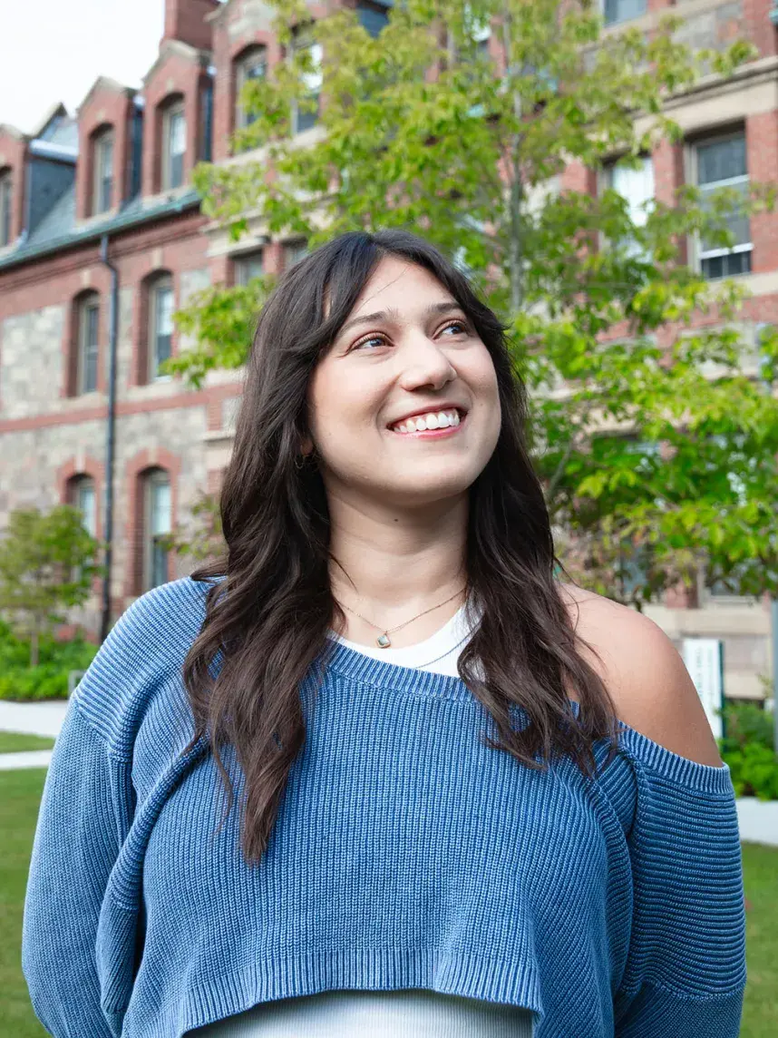 student in front of building