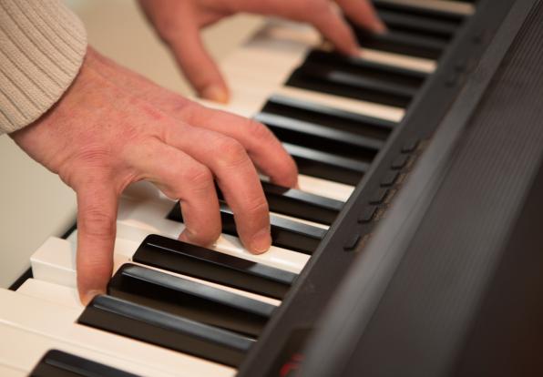 elderly hands playing a piano