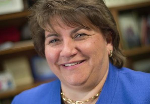 Headshot photograph of Interim Provost Deanna Yameen smiling at the camera wearing a blue blazer.
