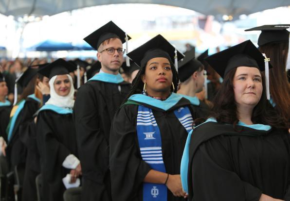 Graduate students stand at commencement