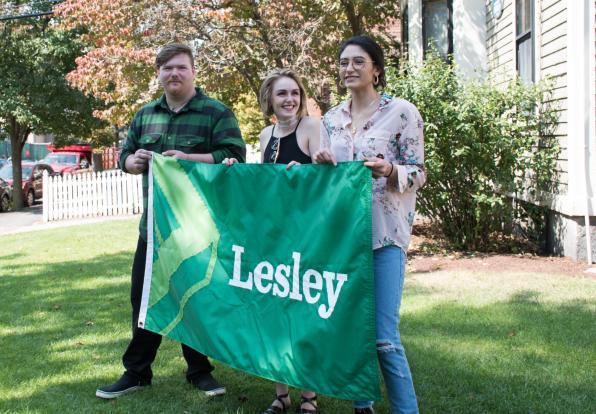 Students Michael Coleman, Raine Ferrin and Christine Lopez Corado hold the new Lesley flag that they designed.