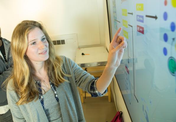 students interact with smartboard in classroom 